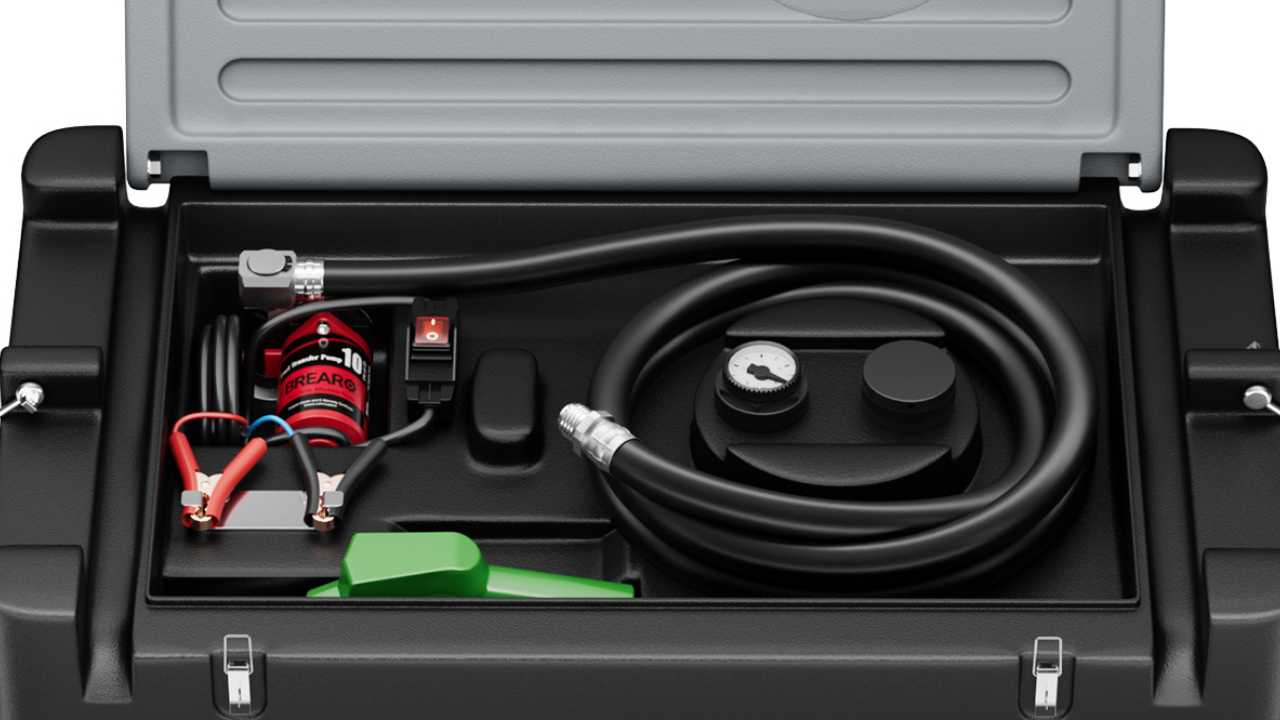 Close-up view of a fuel transfer pump system with hoses, clamps, and gauges inside a protective casing