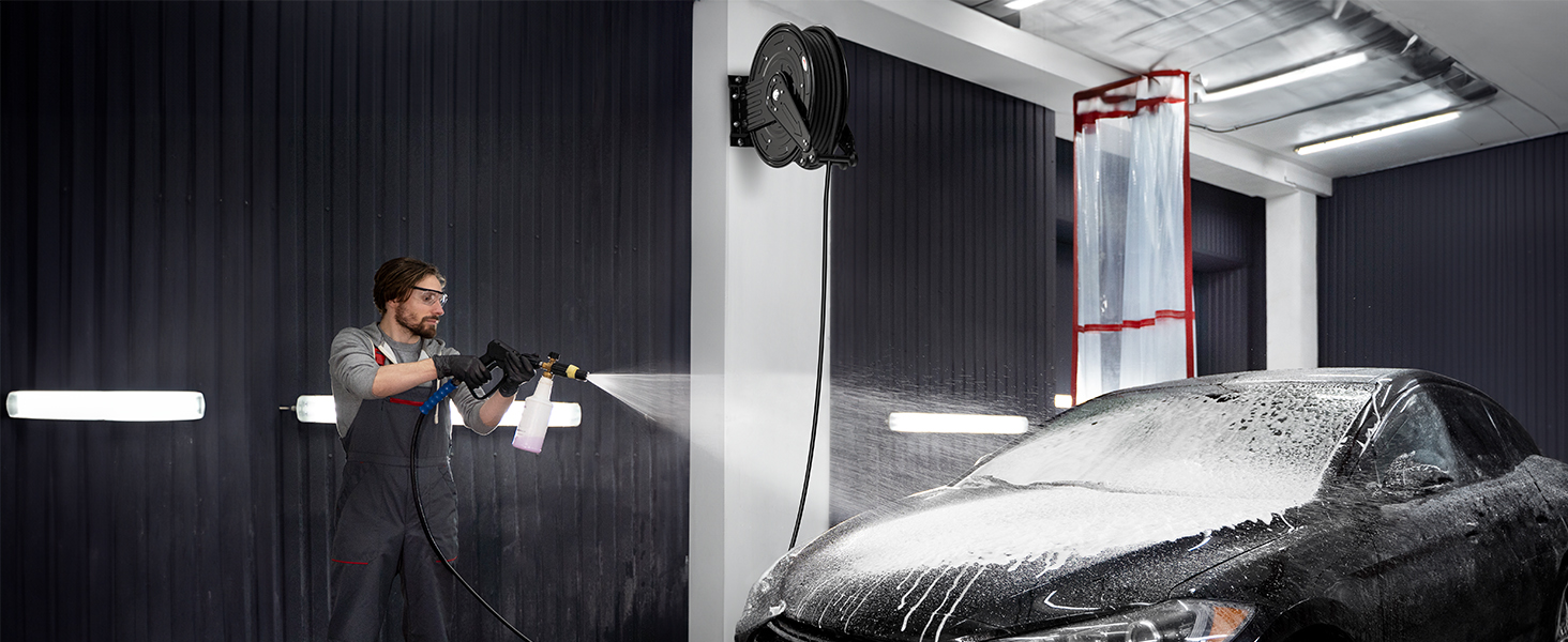 BreAro retractable hose reel in use during a car wash. Wall-mounted for convenience, it provides smooth operation and efficient cleaning, ideal for professional automotive detailing and maintenance tasks.