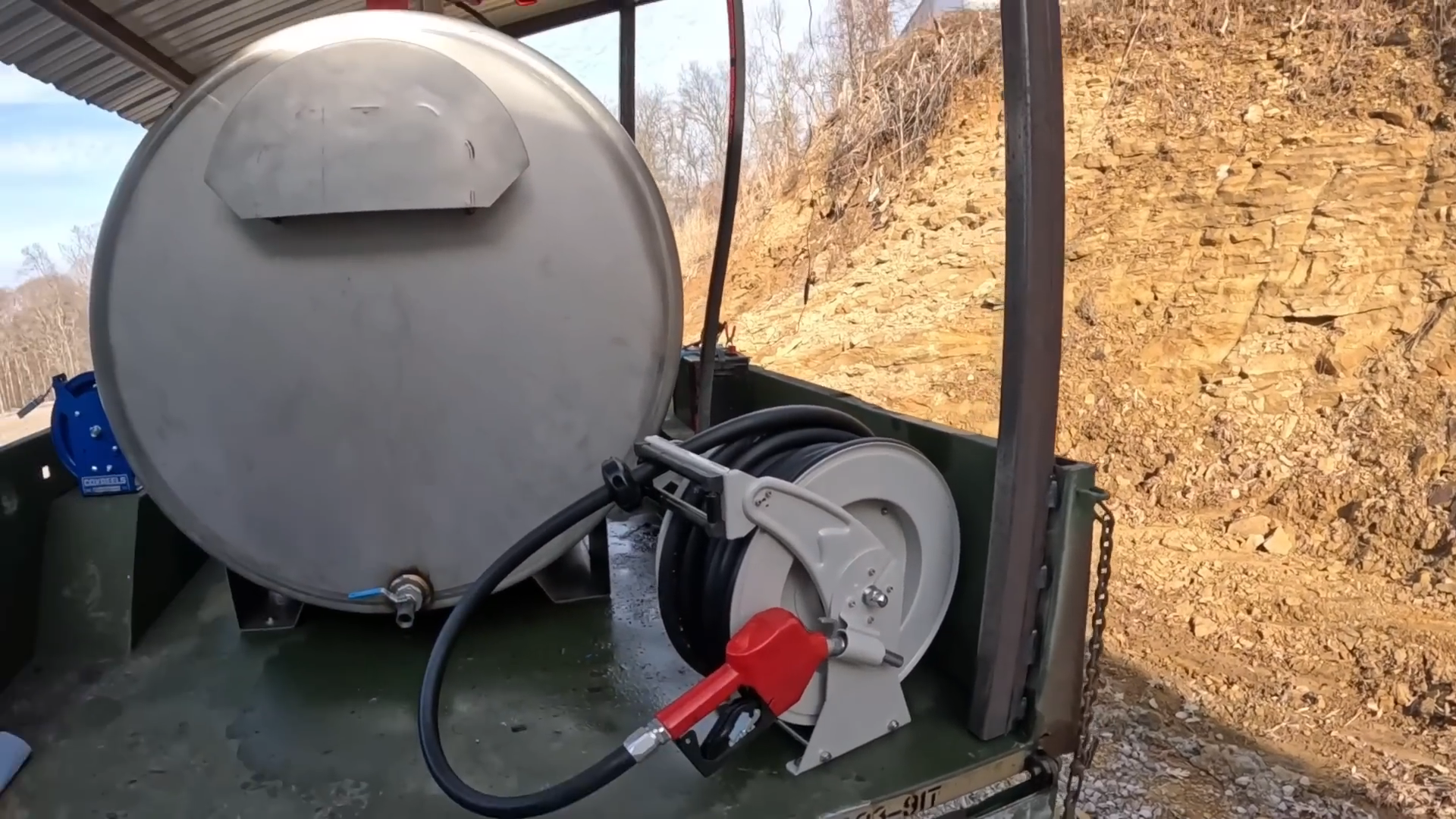 Modern fuel hose reel setup on a farm, showcasing a clean and organized fueling system with a hose neatly coiled for efficient use.