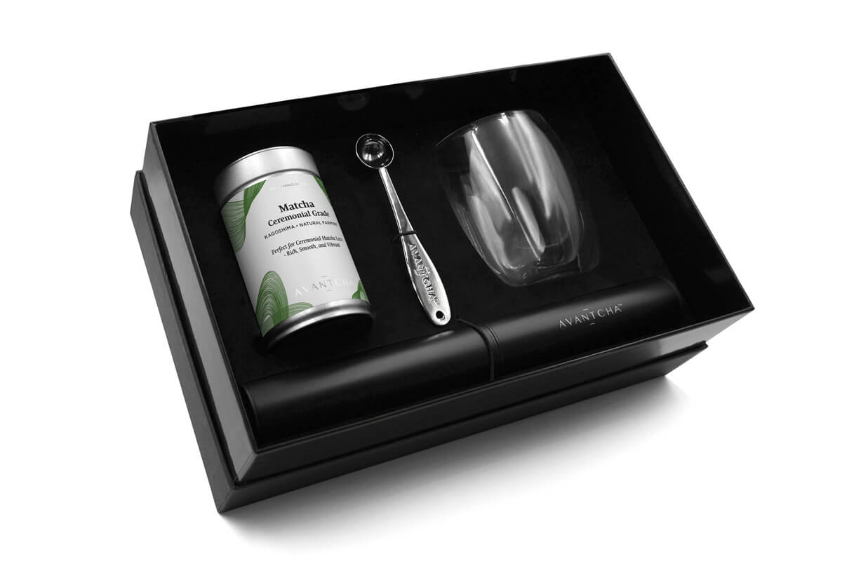 Opened Matcha Latte Gift Set showing AVANTCHA Matcha Ceremonial Grade Kagoshima tin, double-walled glass, electric whisk, and matcha spoon in a premium gift box.
