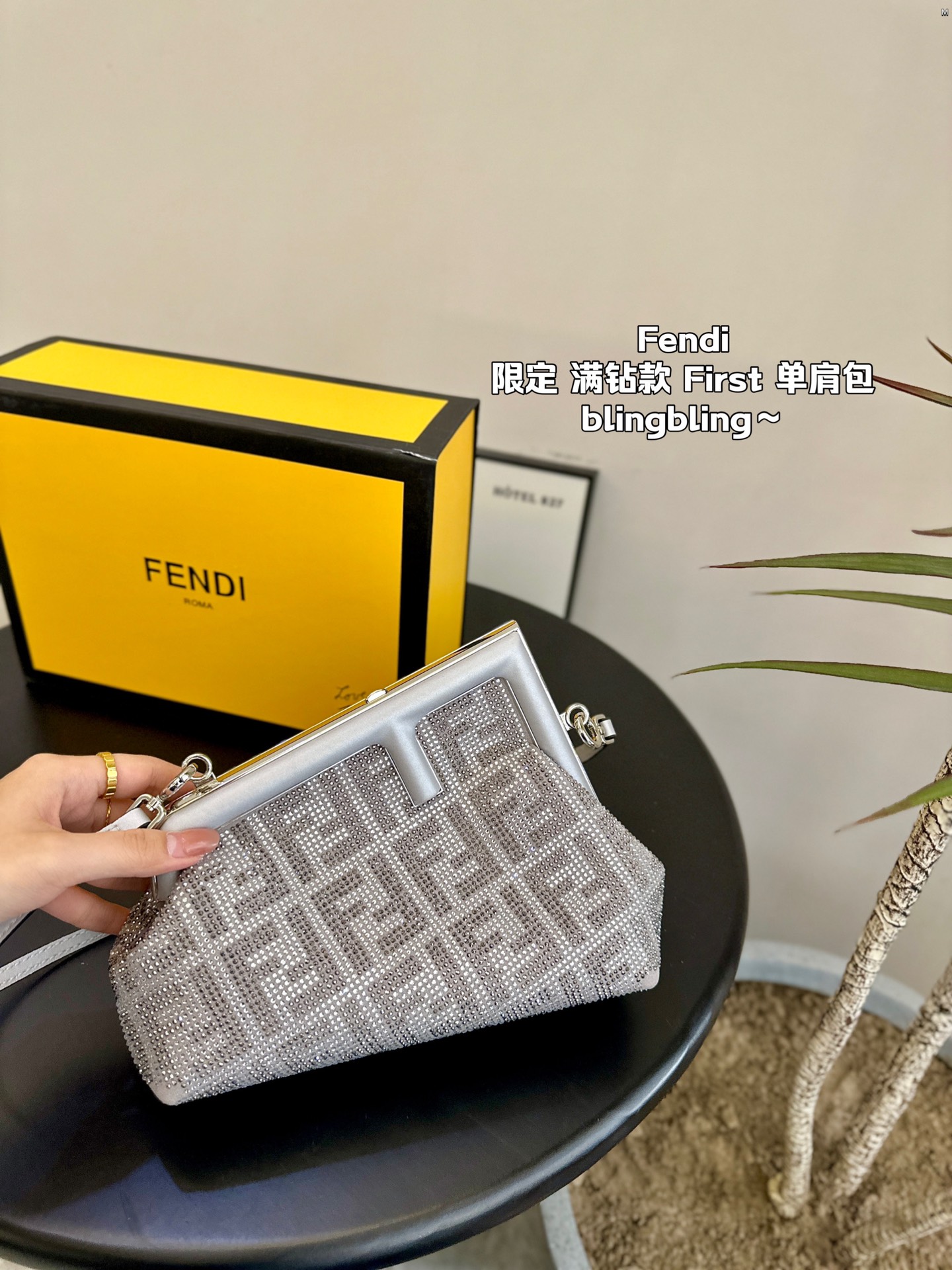 F-I Rhinestone with First shoulder bag in hand.