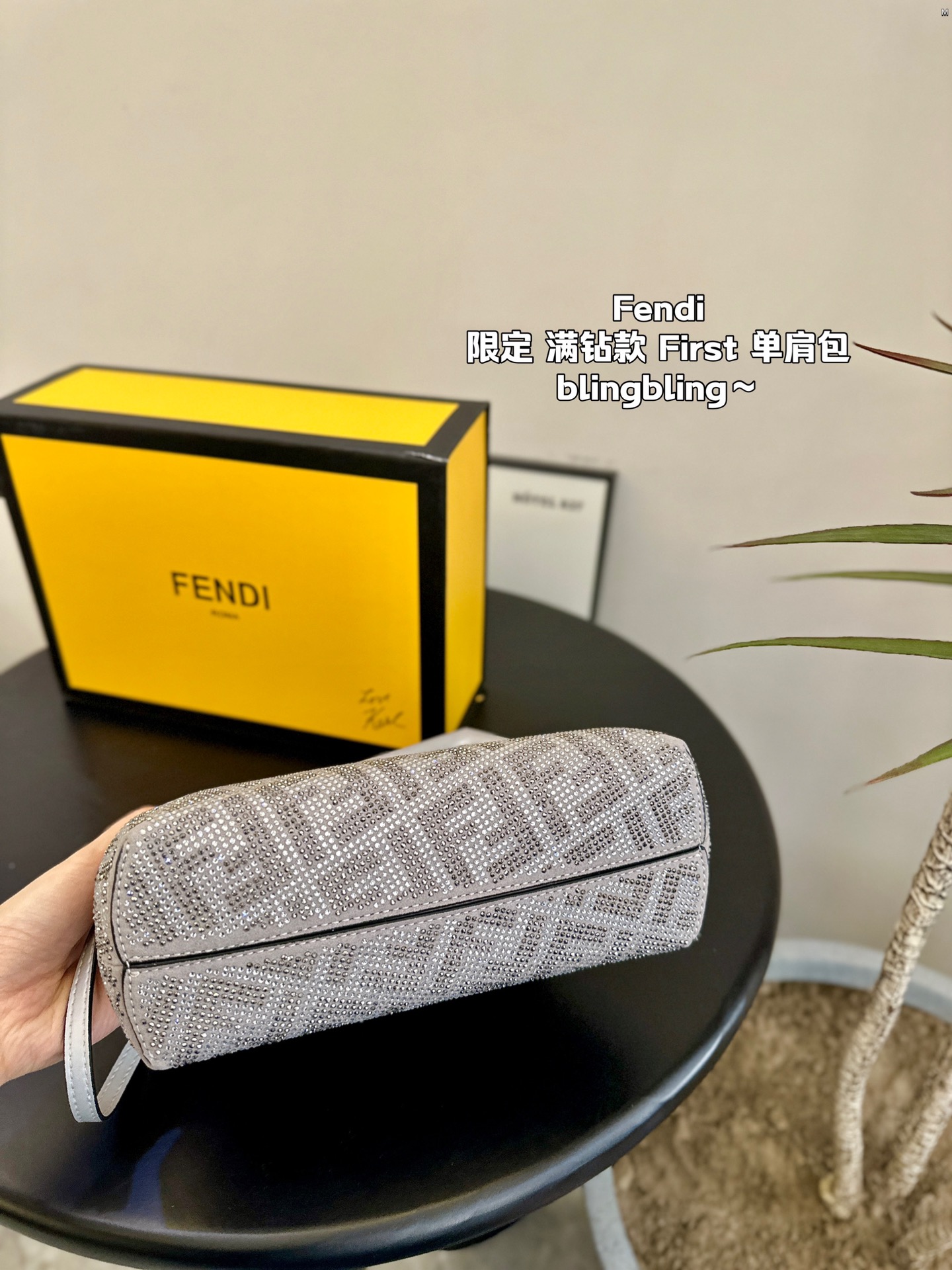 F-I Rhinestone with First shoulder bag in hand.