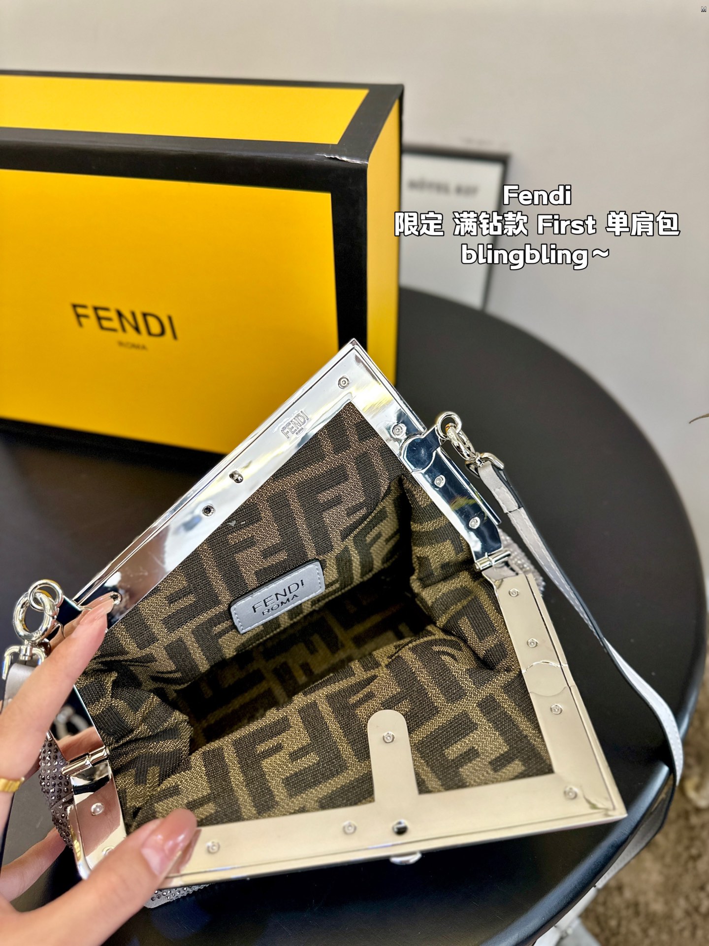 F-I Rhinestone with First shoulder bag in hand.