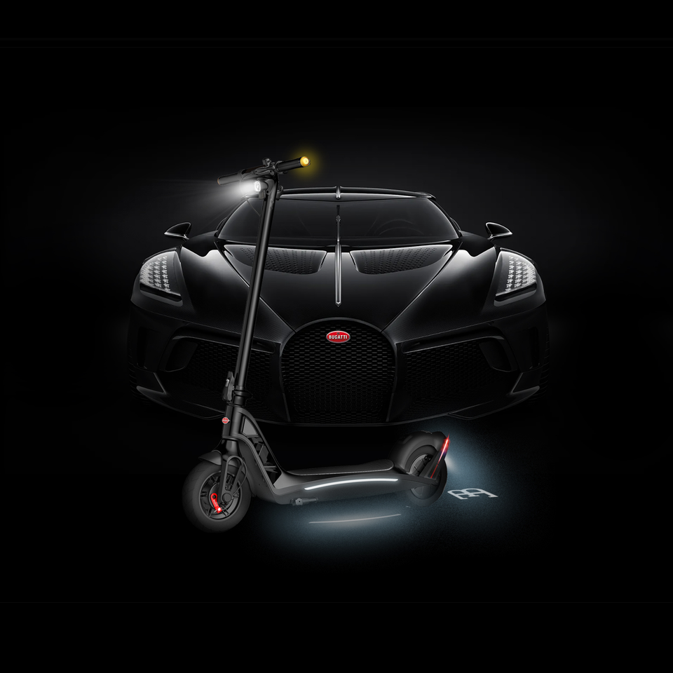 Black Bugatti Vehicle with a Bugatti electric scooter in front with all illumination features activated