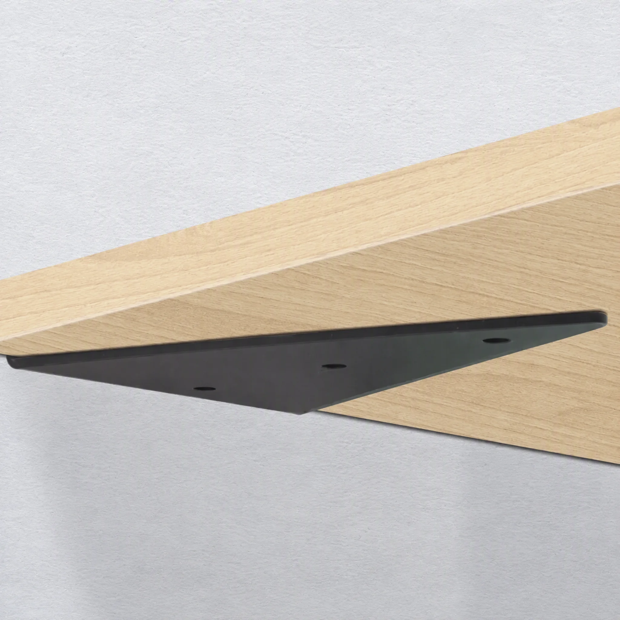 Black steel invisible wall bracket supporting a light oak floating shelf