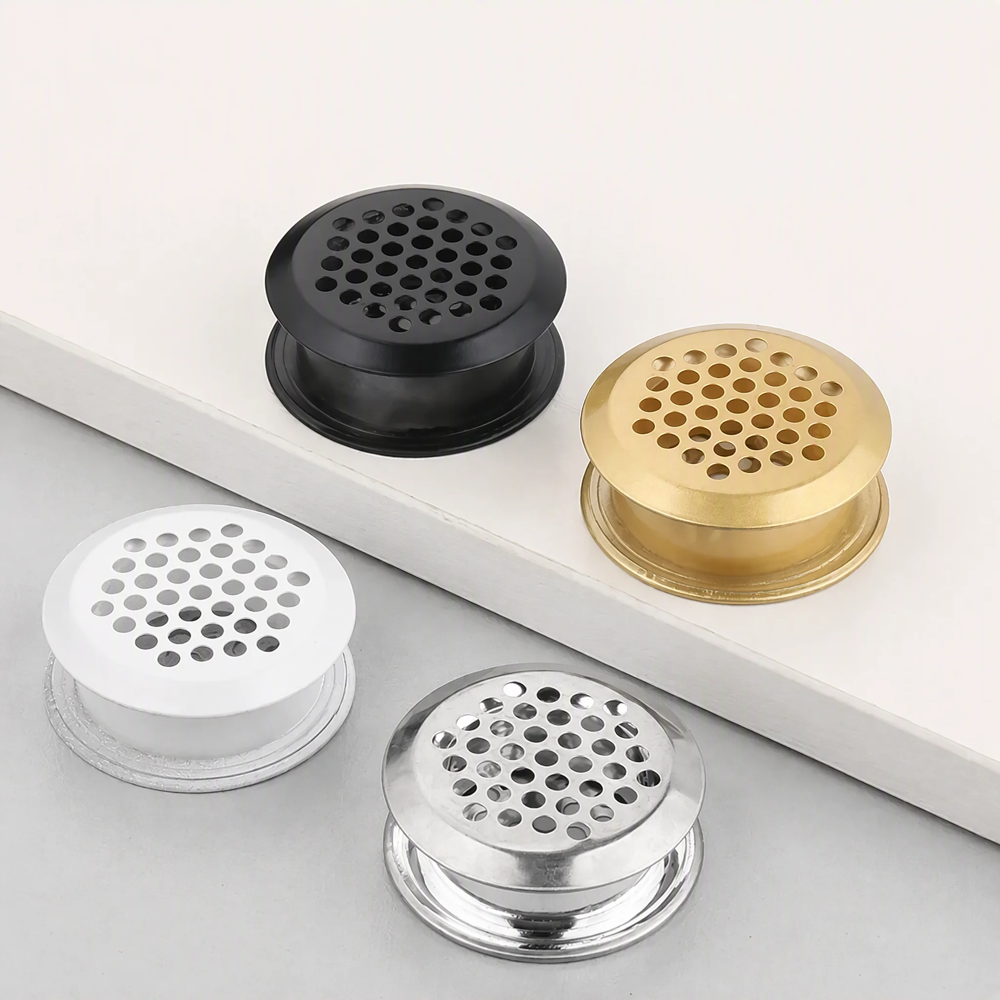 Round stainless steel vent grilles in black, gold, white and chrome