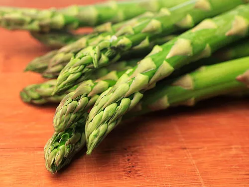 A close up shot of the top of a pile of asparagus spears.