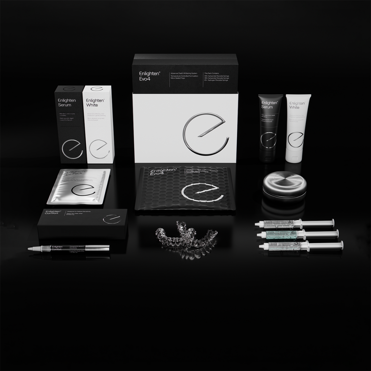 A comprehensive display of the "Enlighten Evo4 Whitening System" kit, showcasing a sleek white and black box with the iconic Enlighten logo at the center. Surrounding it are the Enlighten Serum and White tubes, a desensitising pen with its elegant black packaging box, whitening trays, syringes of whitening gel, a black storage pouch, a silver tray case, and a silver ice pack. Set against a glossy black surface, the arrangement emphasizes the kit's premium quality and professional design.