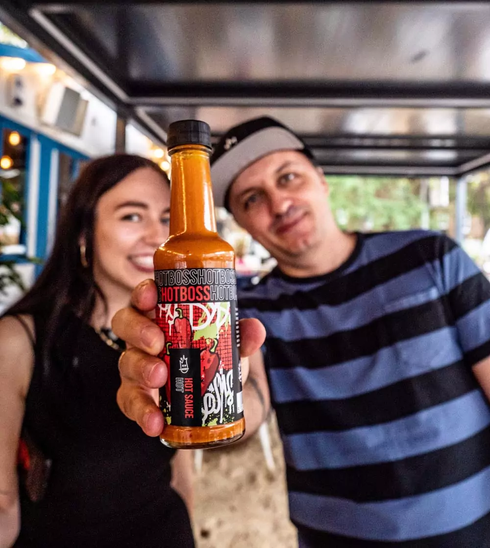 people holding hotboss hot sauce