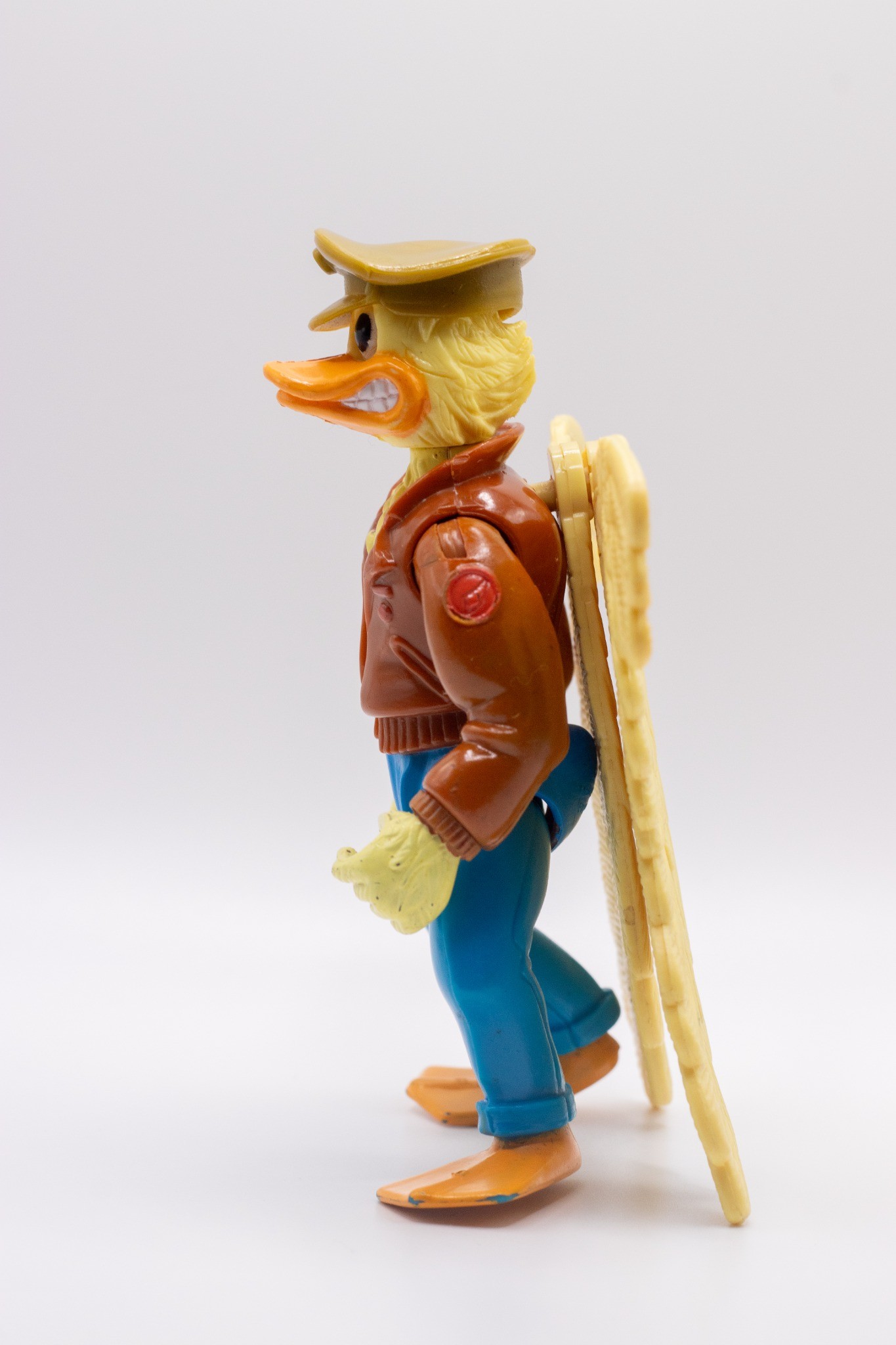 Left-angled shot of Ace Duck action figure with folded wings and wearing hat