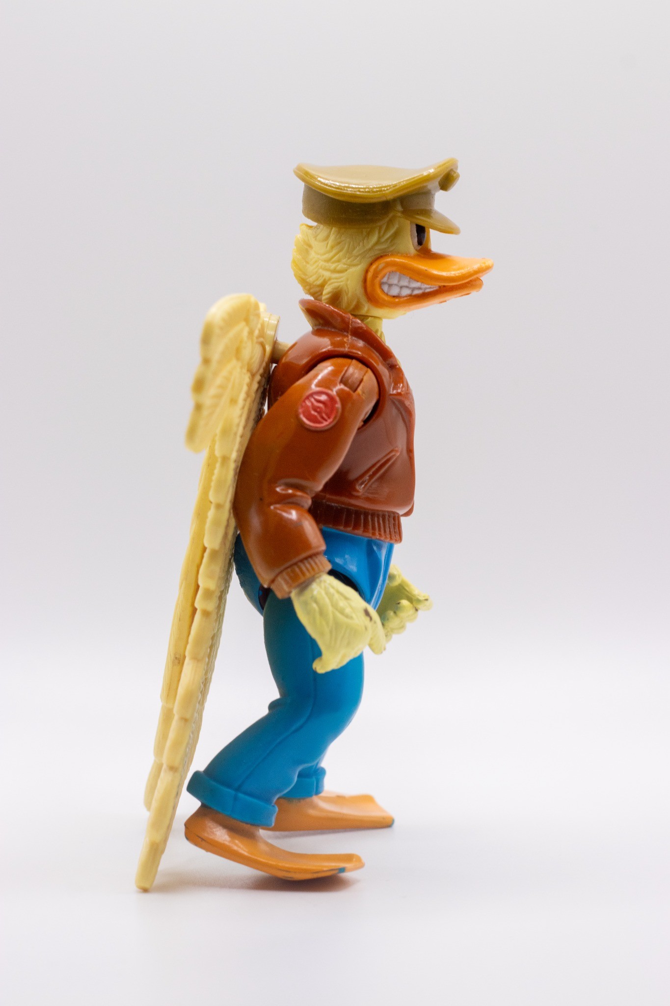 Right-angled shot of Ace Duck action figure with folded wings and wearing hat