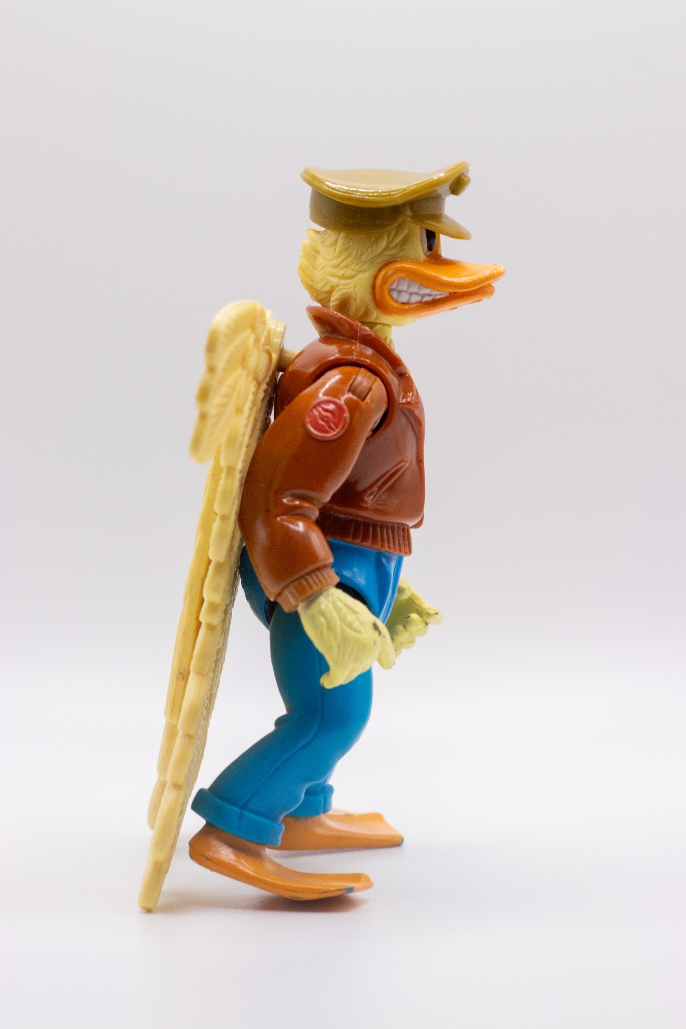 Right-angled shot of Ace Duck action figure with folded wings and wearing hat