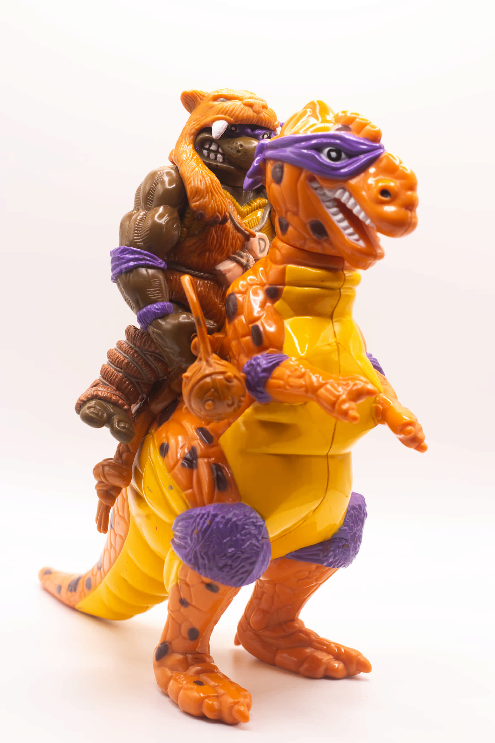 Face on shot of vintage Cave-Turtle Don action figure holding Mesozoic Mace, riding on Trippy Tyrannosaurus
