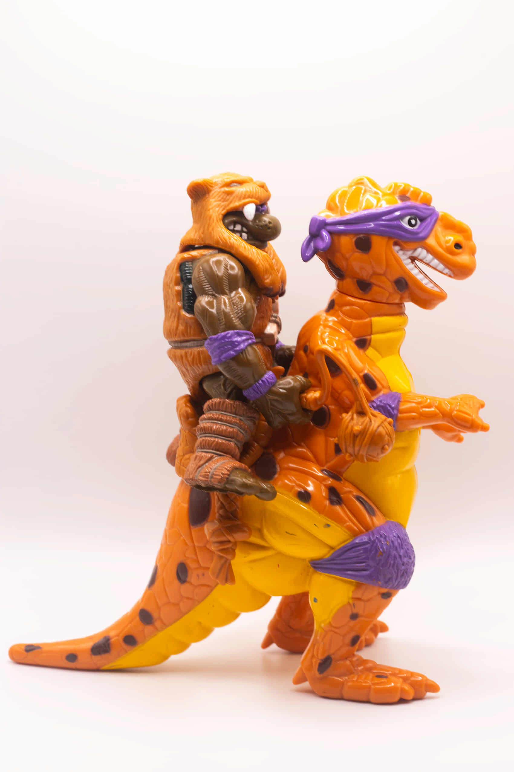 Right side view of vintage Cave-Turtle Don action figure holding Mesozoic Mace, riding on Trippy Tyrannosaurus