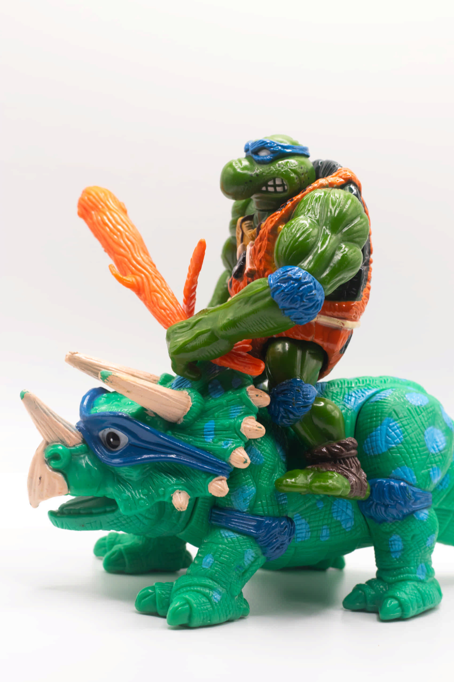 Left side view of vintage Cave-Turtle Leo action figure holding katana and club, riding Dingy Dino