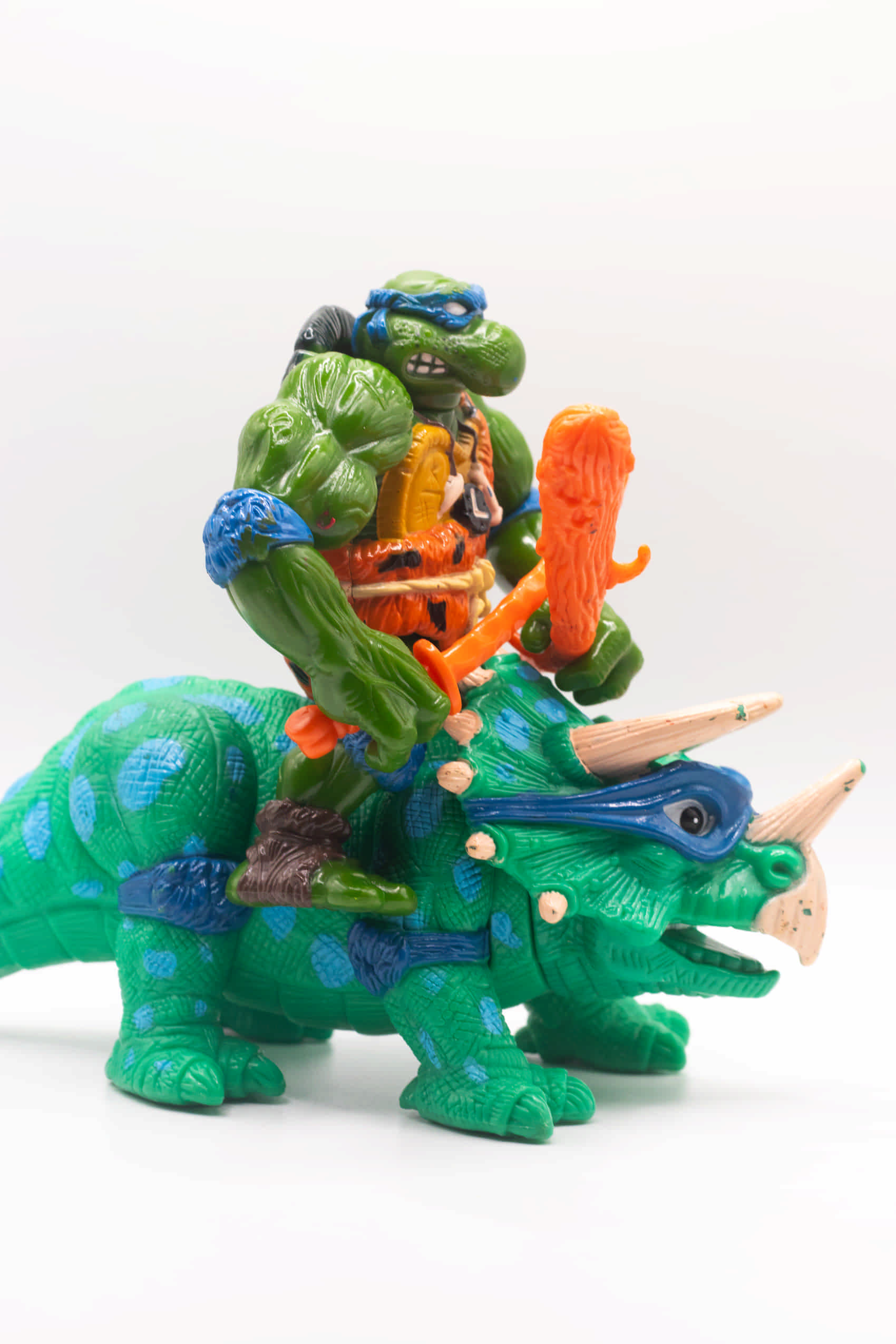 Right side view of vintage Cave-Turtle Leo action figure holding katana and club, riding Dingy Dino