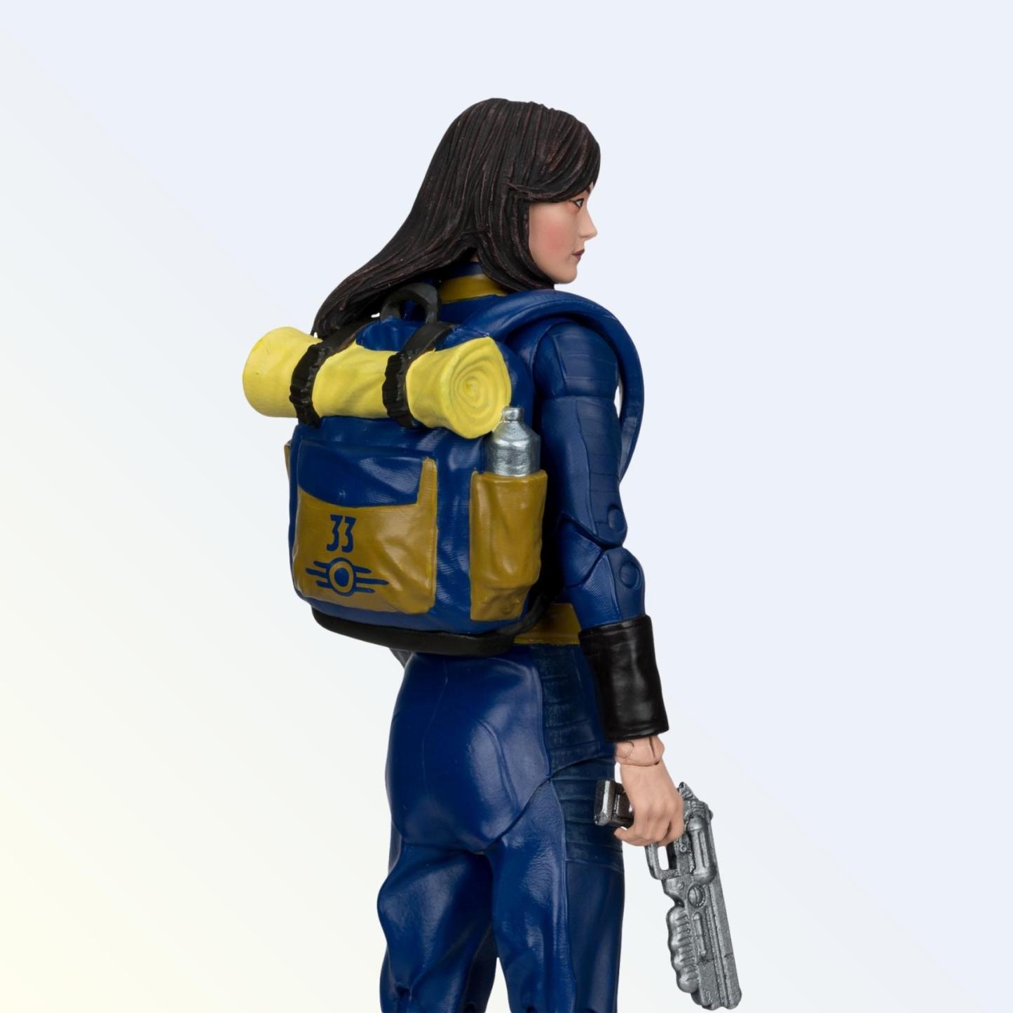 Rear angle of Lucy MacLean action figure showing Vault 33 backpack with bedroll and canister