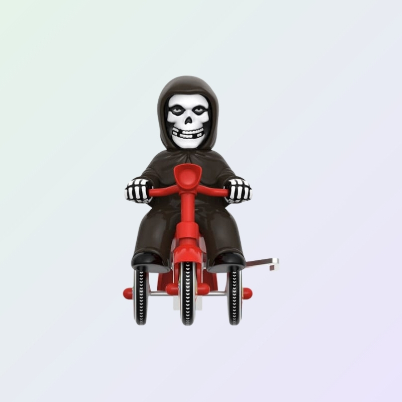 Front view of Misfits The Fiend figure riding red tricycle and wearing a black cloak
