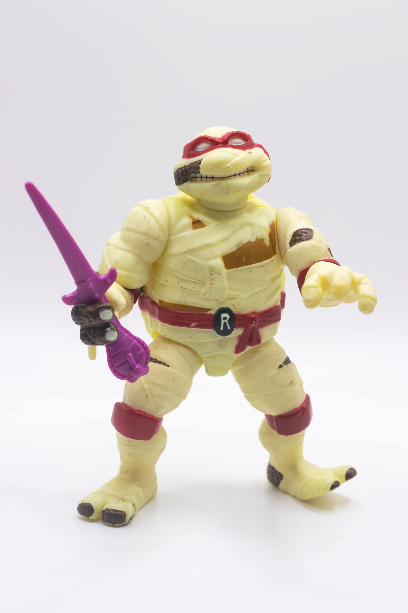 Face on shot of vintage Mummy Raph action figure holding a single Cobra Sai