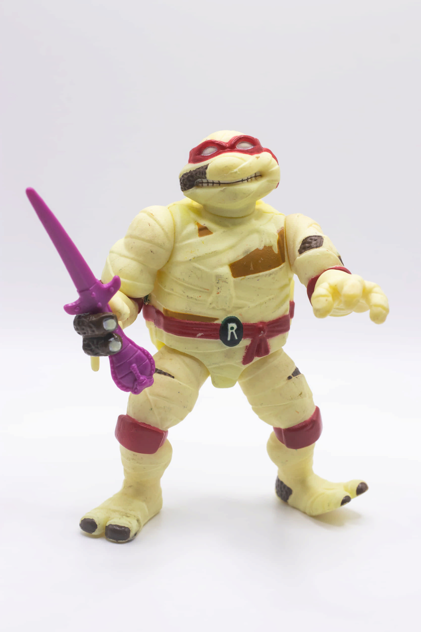 Face on shot of vintage Mummy Raph action figure holding a single Cobra Sai