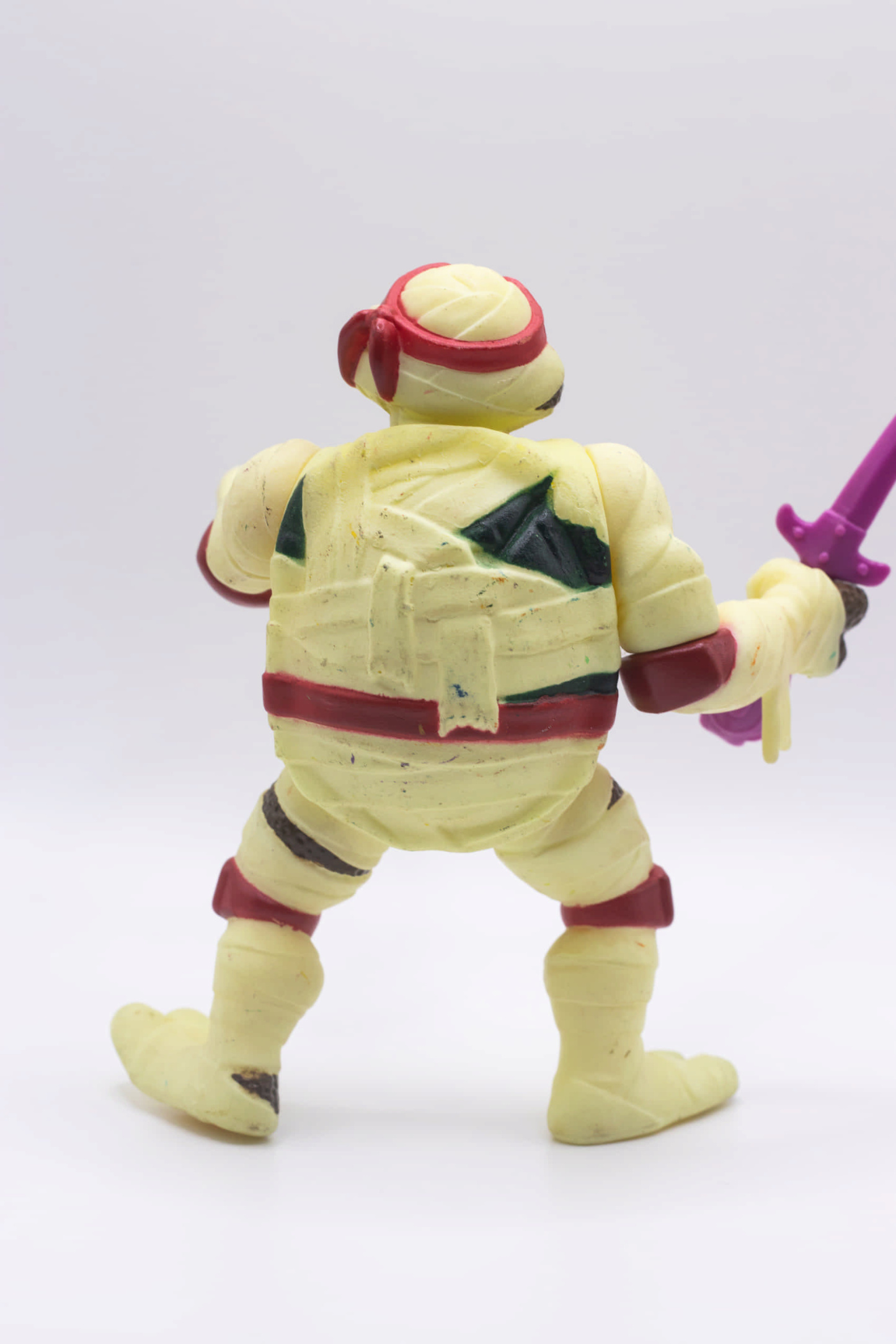 Rear view of vintage Mummy Raph action figure holding a single Cobra Sai
