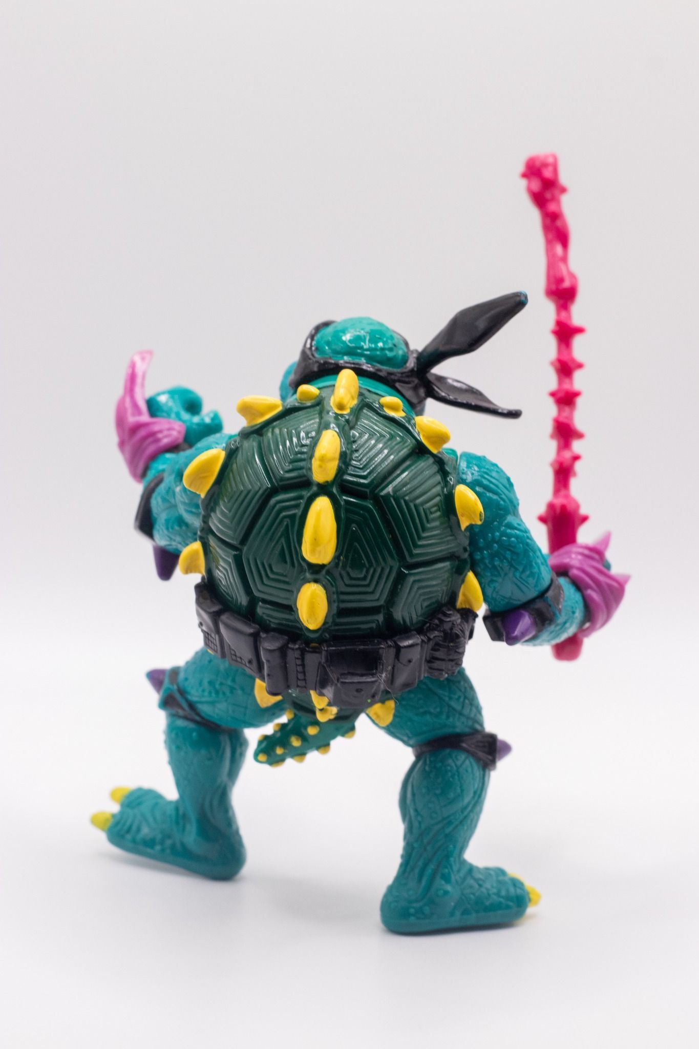 Rear view of TMNT Slash action figure showing green shell and yellow spikes