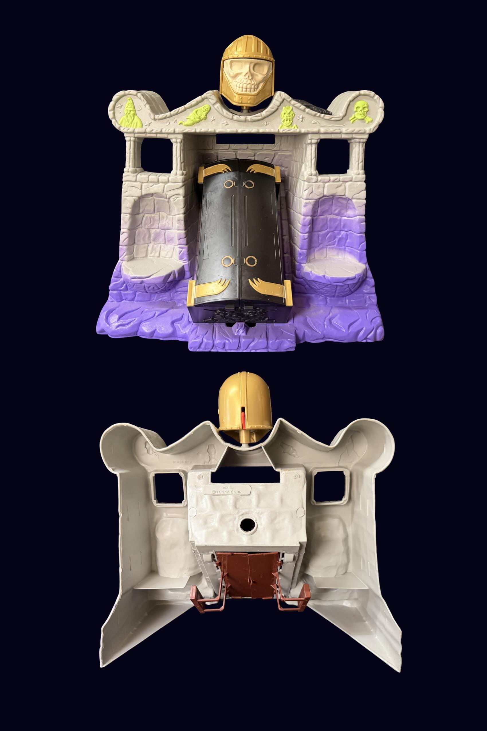 Two views of the Tomb of Doom playset, front view showing black coffin with gold clasps and back view showing the grey underside and gold skull helmet attached