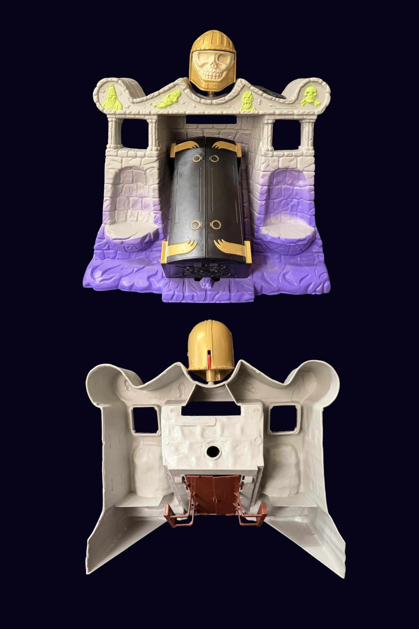 Two views of the Tomb of Doom playset, front view showing black coffin with gold clasps and back view showing the grey underside and gold skull helmet attached