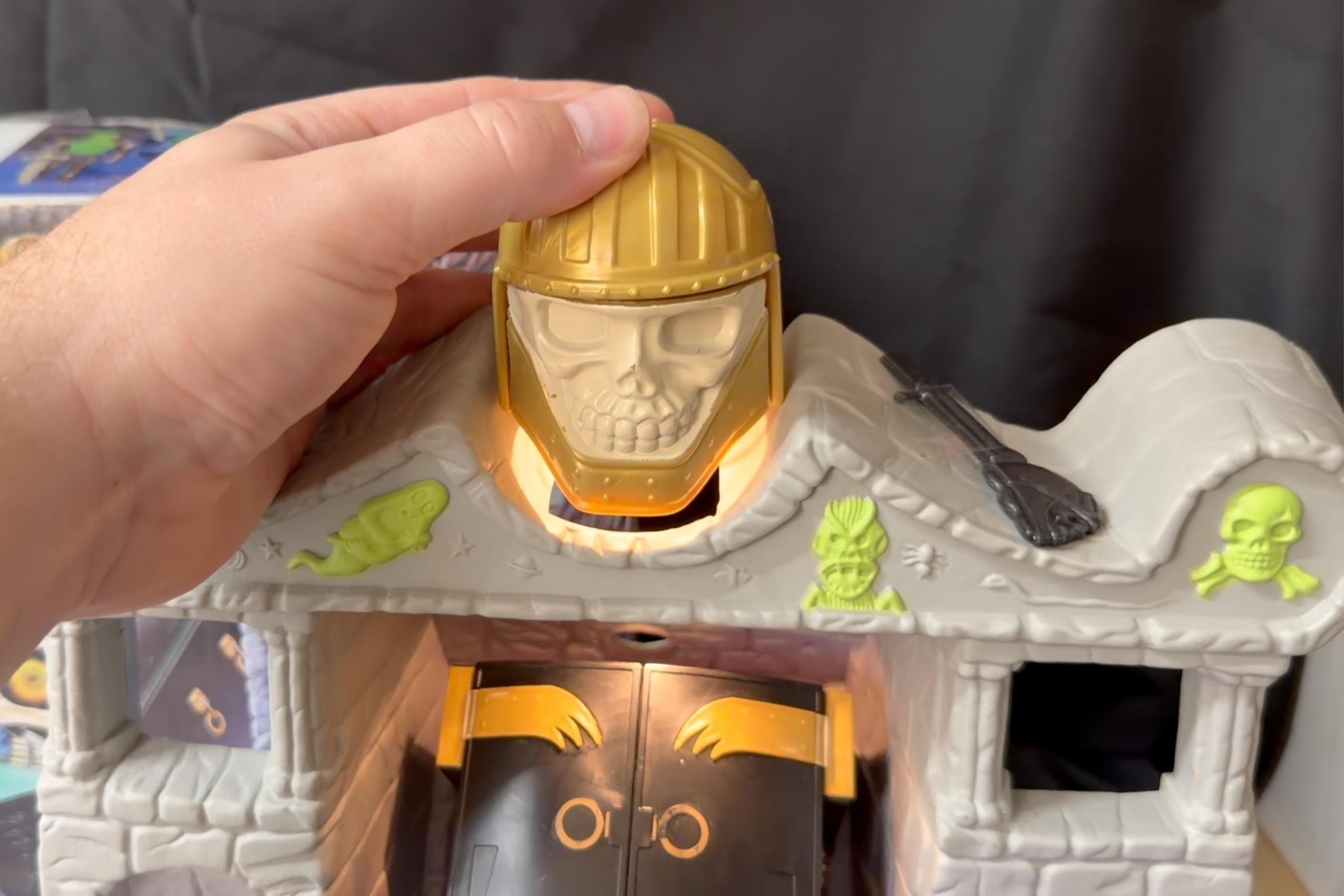 Close-up of gold skull-helmet flashlight from the top of the Tomb of Doom playset