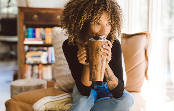 A Woman sitting on a chair with a Toddy XL in her hand.