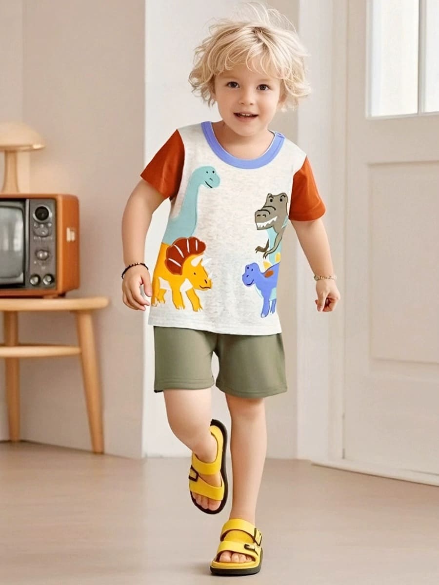 5-year-old boy smiling in blue dinosaur embroidery cotton shorts and tee at room
