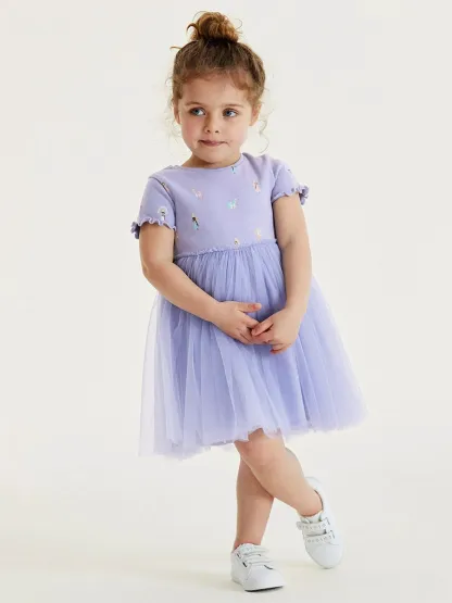 Toddler girl wearing a cartoon printed tulle princess dress by Little Maven