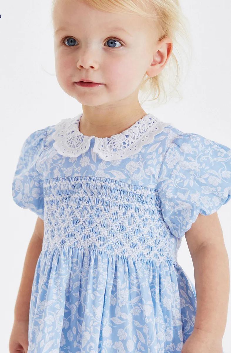 Toddler girl wearing a small floral puff sleeve cotton dress by Little Maven