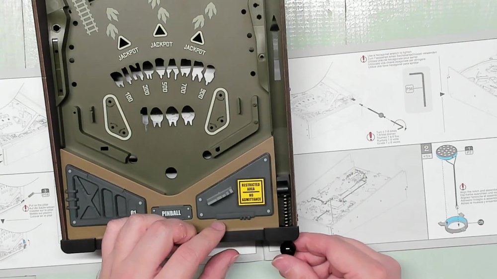 Builder working at the plunger end of the Dinosaur Lab playfield during Stage 1