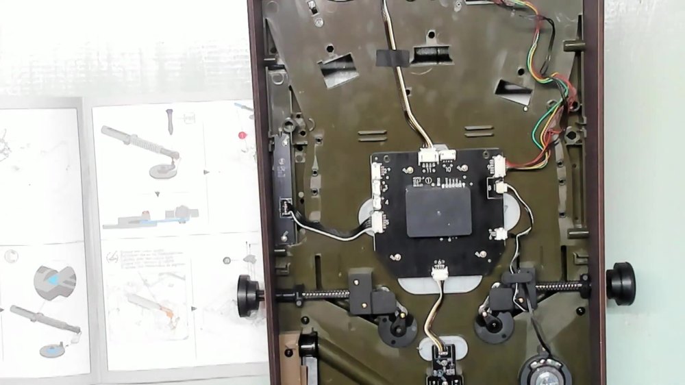 Underside view of the Dinosaur Lab playfield showing flipper buttons, wiring, and control board