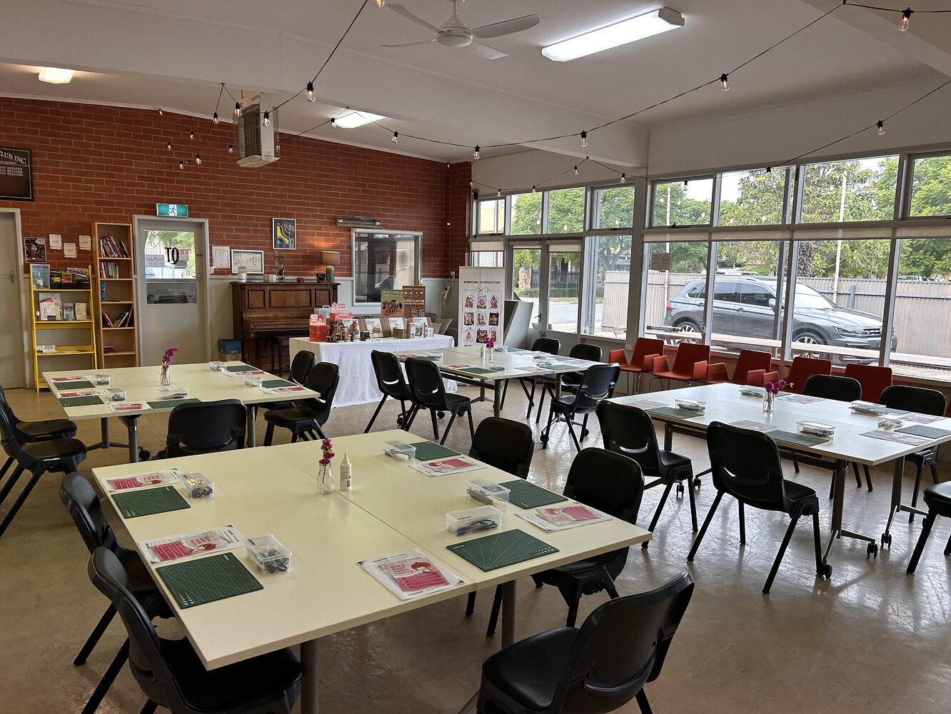 Tables prepared beneath festoon lights and large windows at the QT Hub