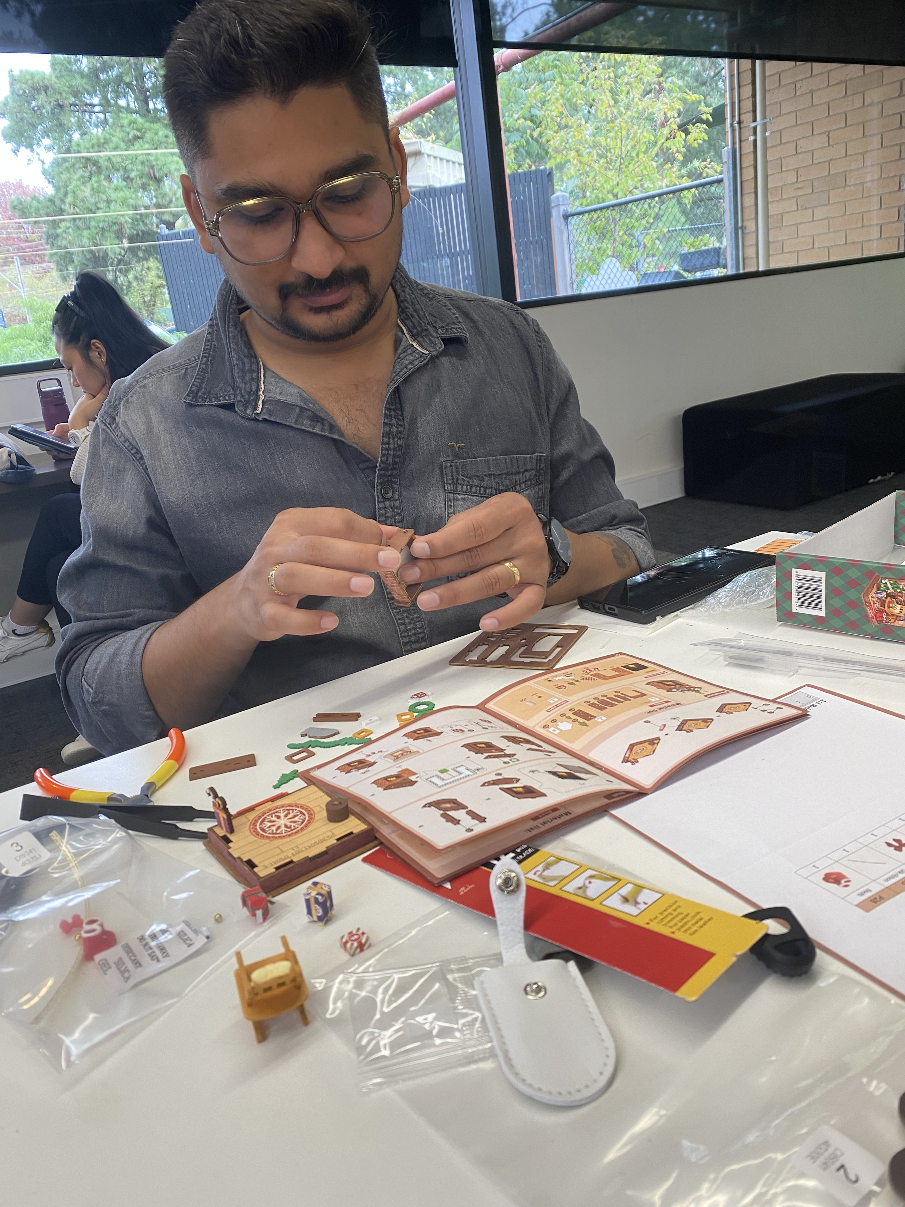 A participant carefully assembling a miniature kit during the Melbourne Robotime workshop