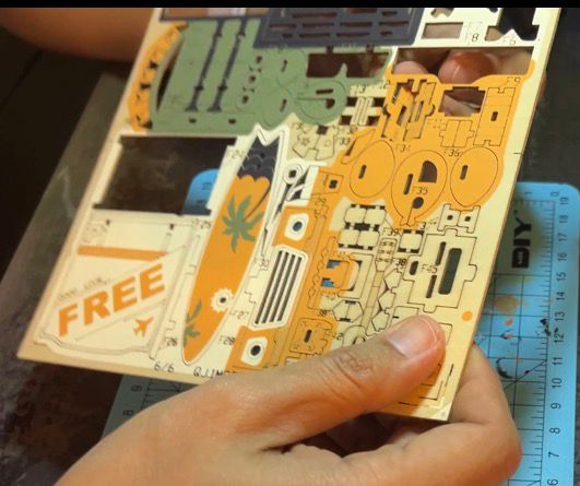 Aiffah holding the thin F-board wooden sheet during the Road Tripper build