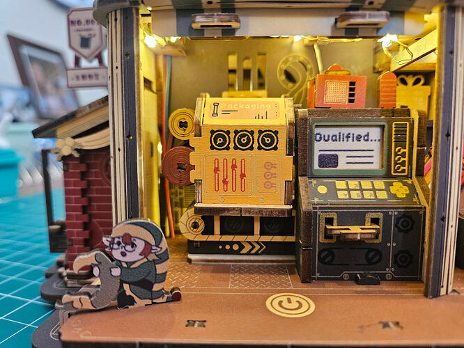 Layered factory details, from upper structure to conveyor path, in Harley's build.