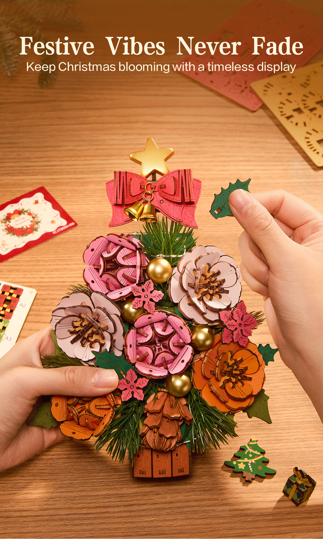 Hands arranging layered flowers and holly accents on Everglow Christmas Tree