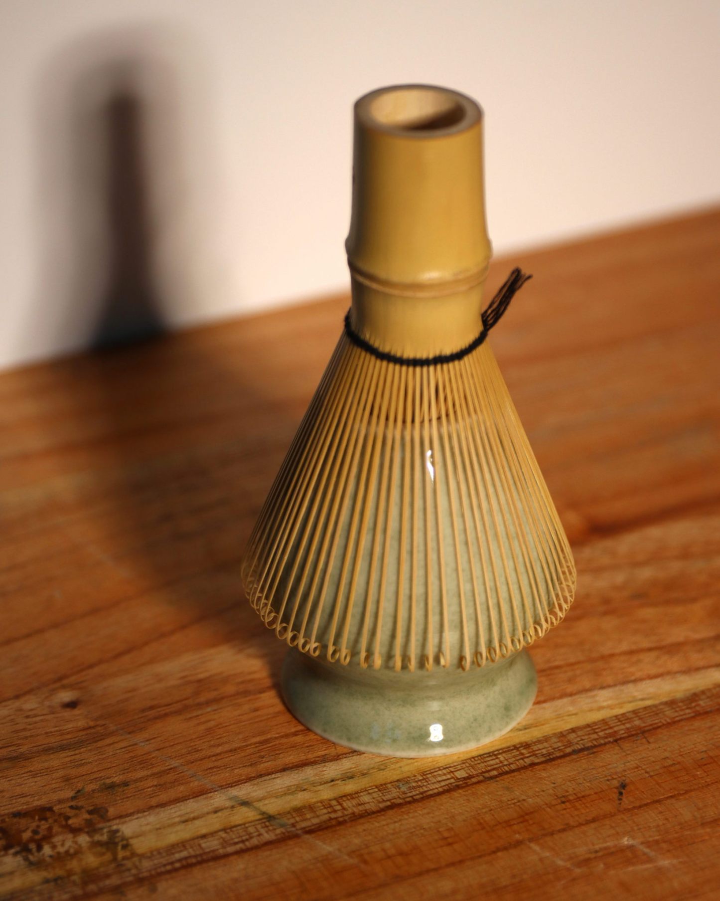 kazuho white bamboo whisk on a whisk stand.