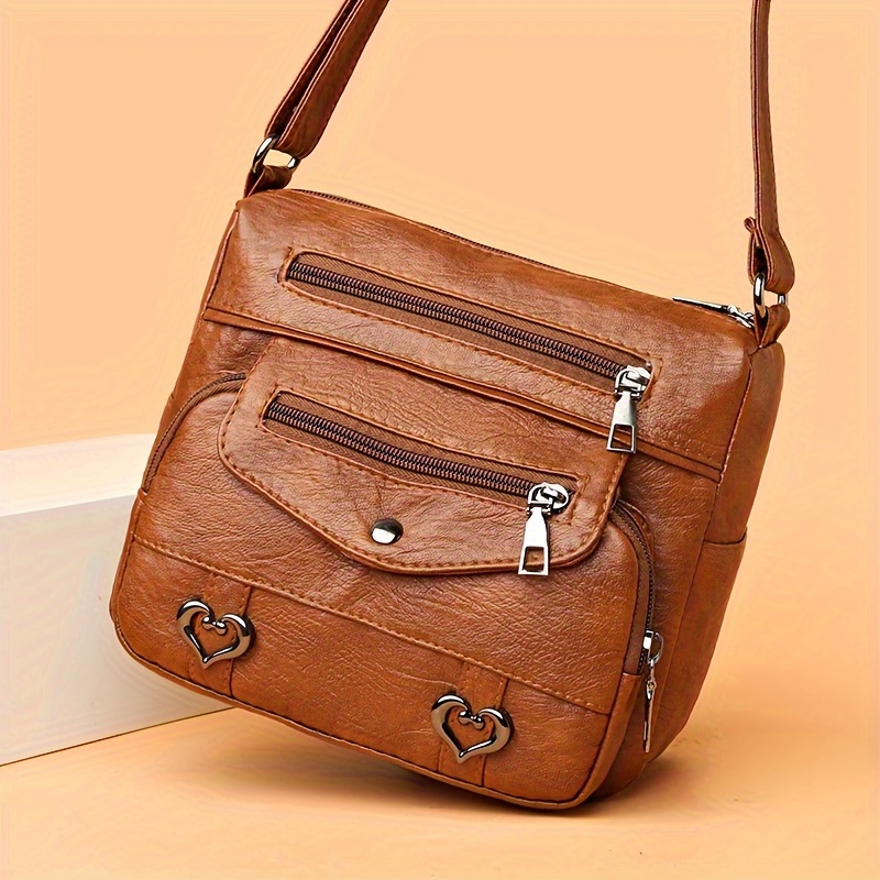 🎀Retro crossbody kabelka s více kapsami, taška přes rameno z měkké PU kůže, dámská kabelka s kovovým srdcem 💼