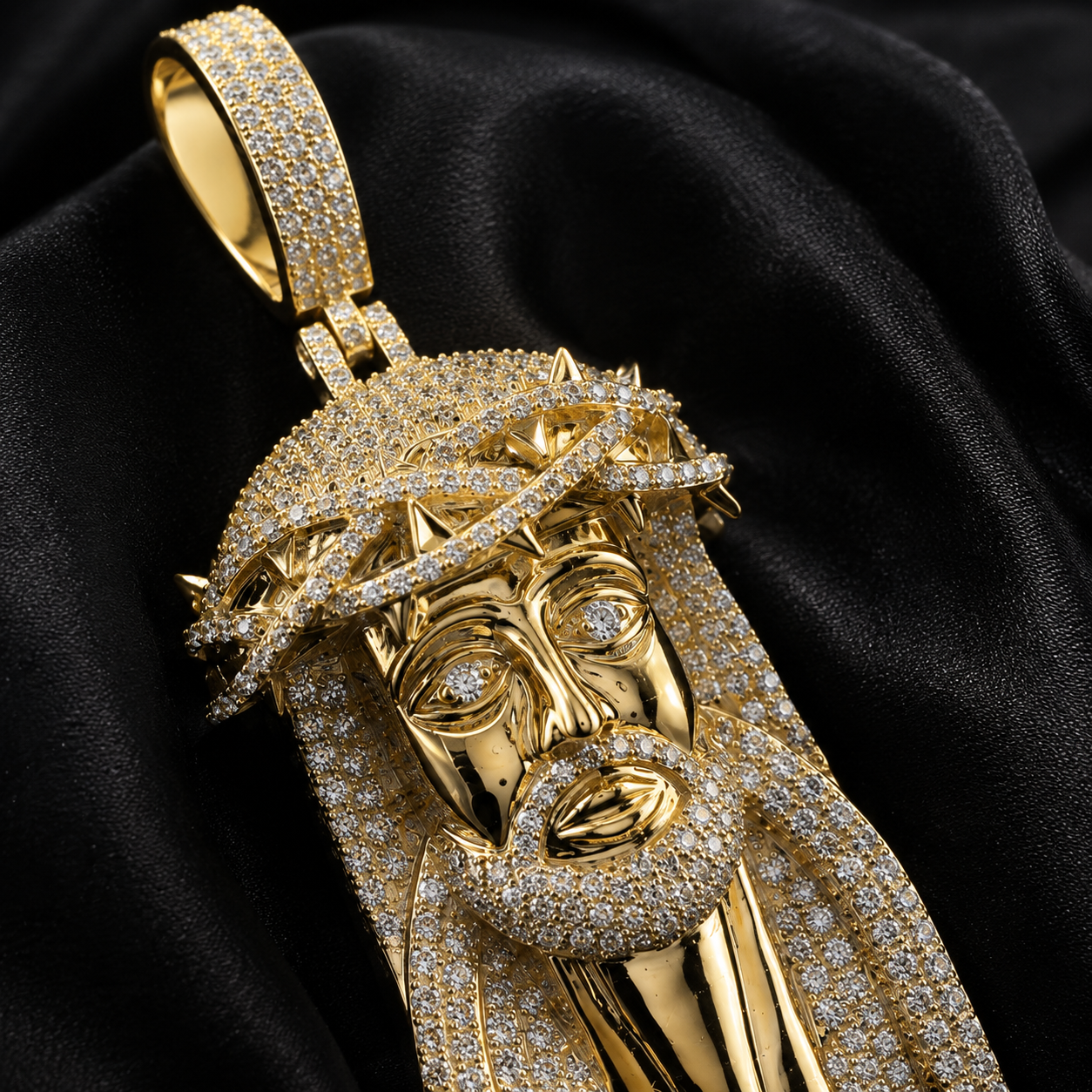 Close-up of gold Jesus face pendant with iced out thorn crown and pavé stones
