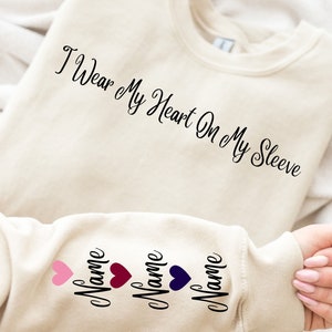 I Wear My Heart On My Sleeve Sweatshirt and Hoodie, Custom Family Gift Hoodie, Gift for Mom, Custom Mama Sweatshirt with Name on Sleeve-ilovevango