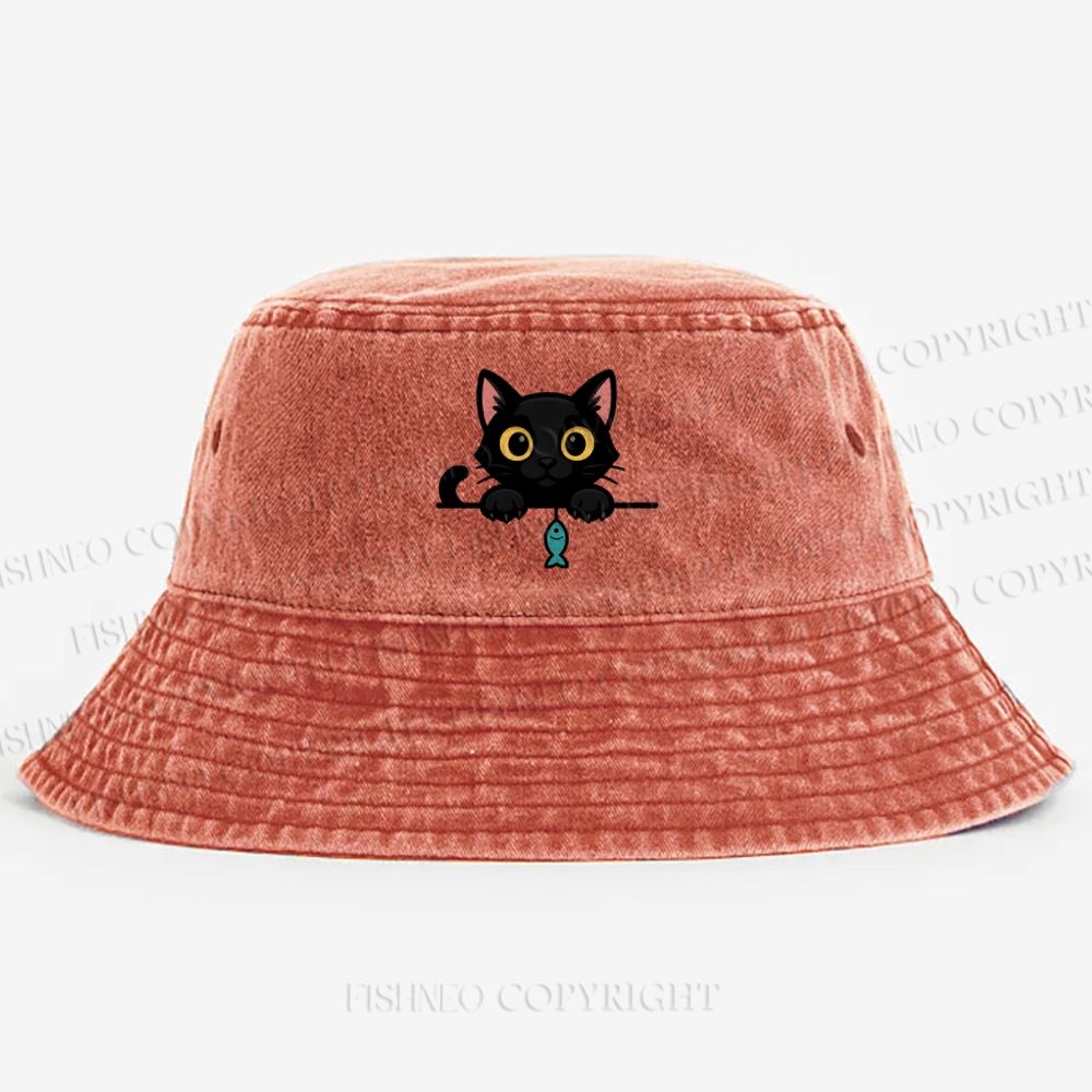 Midnight the black cat holding a tiny yarn ball between both paws while peeking Washed Bucket Hat