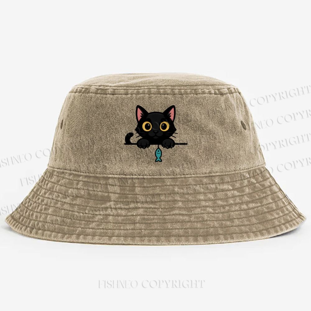 Midnight the black cat holding a tiny yarn ball between both paws while peeking Washed Bucket Hat