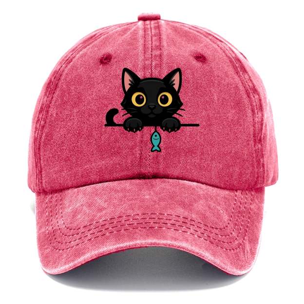Midnight the black cat holding a tiny yarn ball between both paws while peeking Washed Cap