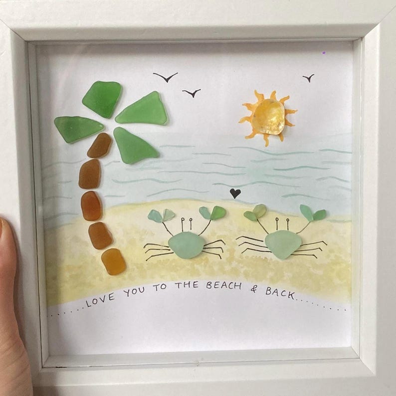 May include: Framed beach-themed artwork featuring a palm tree, sun, and two crabs, all crafted from sea glass. The artwork includes the text "LOVE YOU TO THE BEACH & BACK" in a white frame.