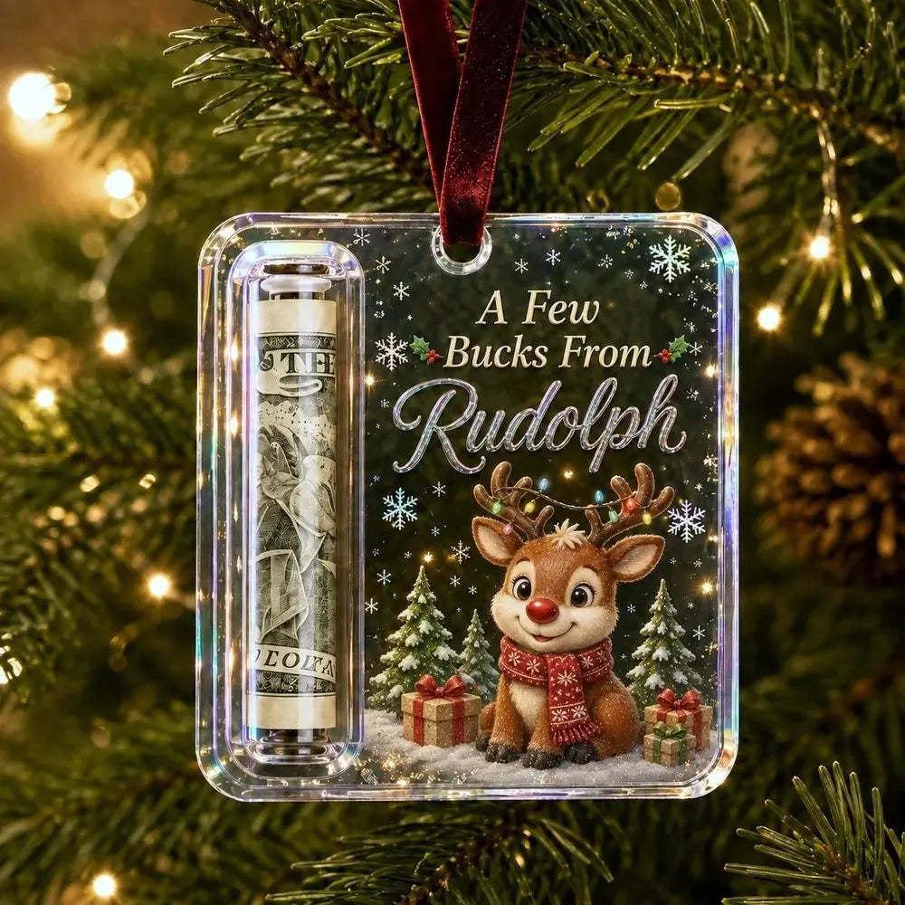 A personalized Christmas ornament hanging on a decorated Christmas tree. The clear square ornament features a printed design with the text 'A Few Bucks From Rudolph' above an illustration of a reindeer wearing a red scarf, a dollar bill roll, snowflakes, and holiday trees.