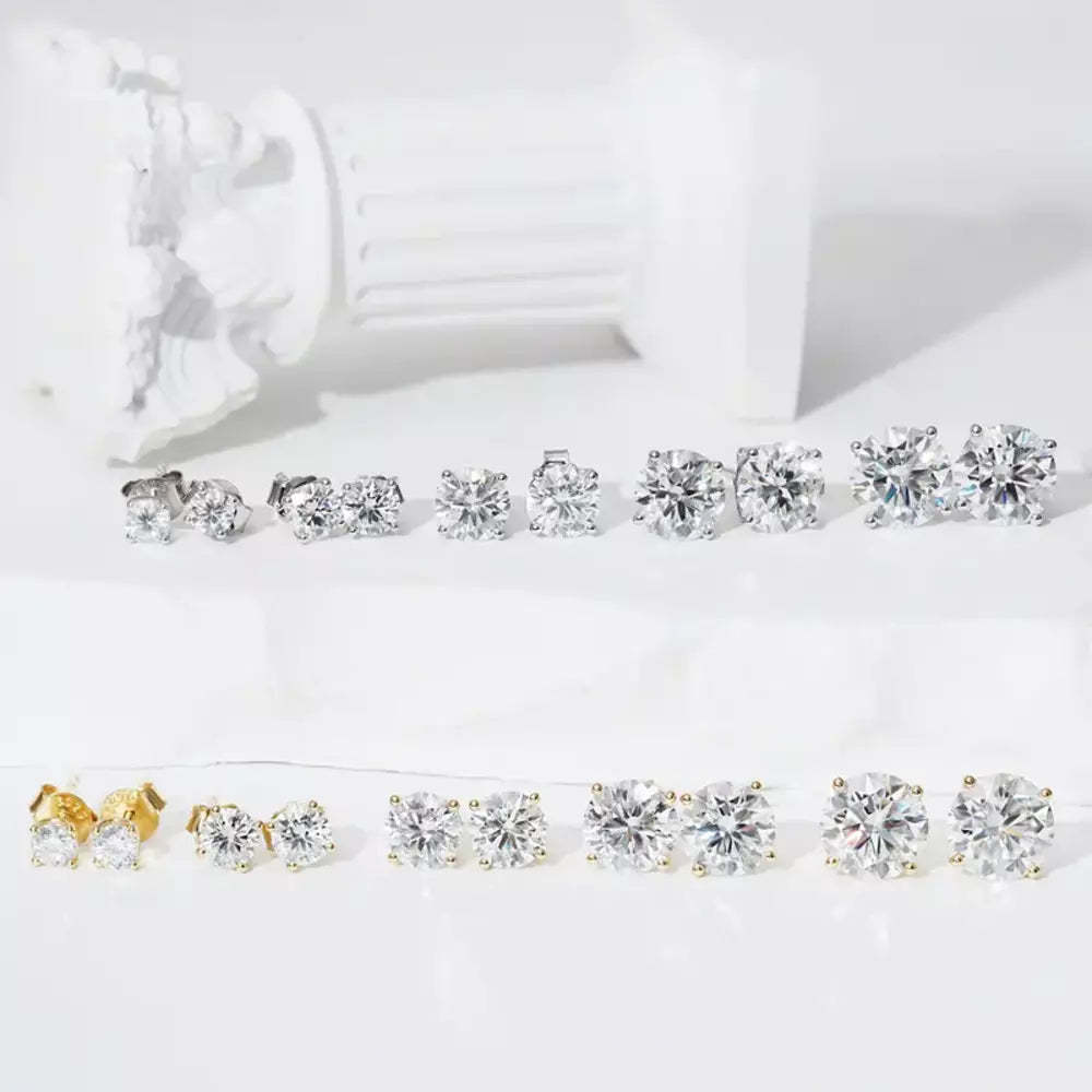 Pair of solitaire moissanite stud earrings displayed with jewelry